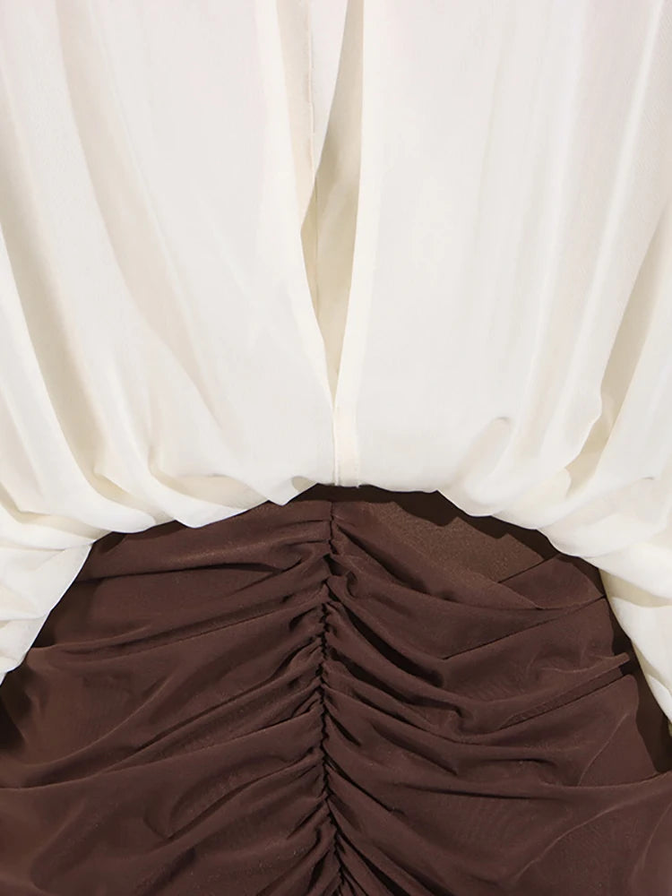 Side angle of designer two-tone pleated slim-fit midi dress with floral detail.