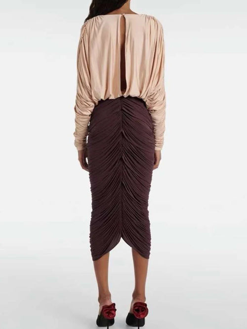 Back view of chic pleated midi dress with long sleeves and deep V-neckline.