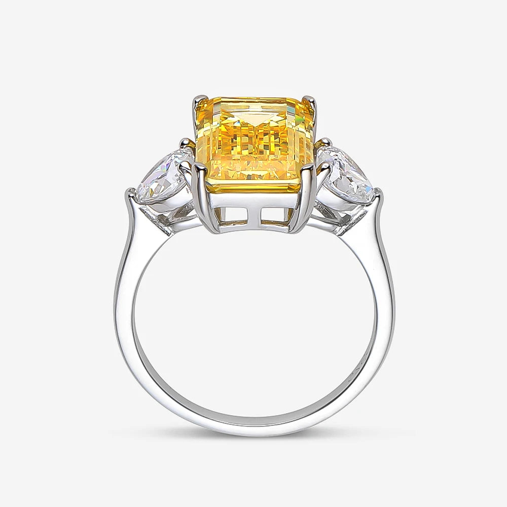 Ring with a yellow gemstone and two smaller diamonds on a white background