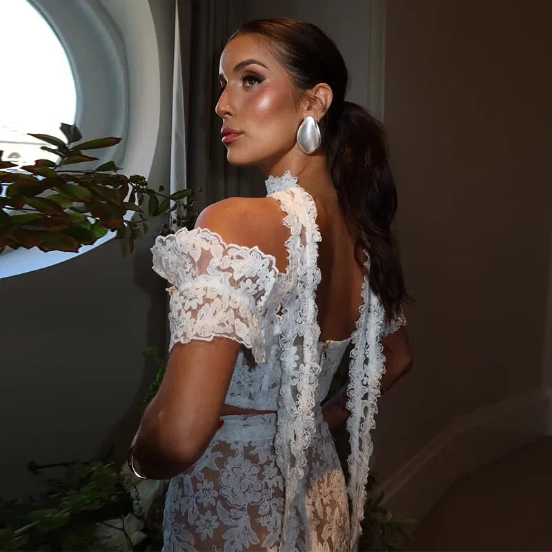 Back view of sheer lace crop top and fitted white mini skirt set with romantic details