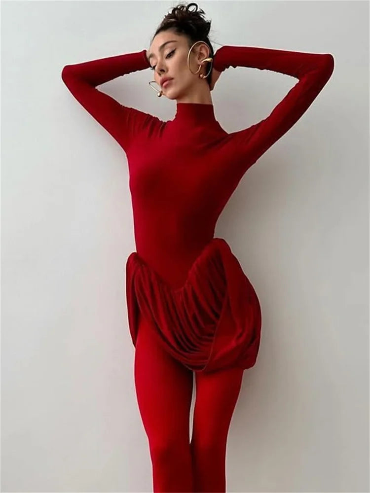 Person wearing a red outfit with a ruffled bottom section against a plain background
