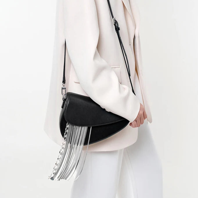 Person wearing a white outfit with a black and silver handbag on a white background
