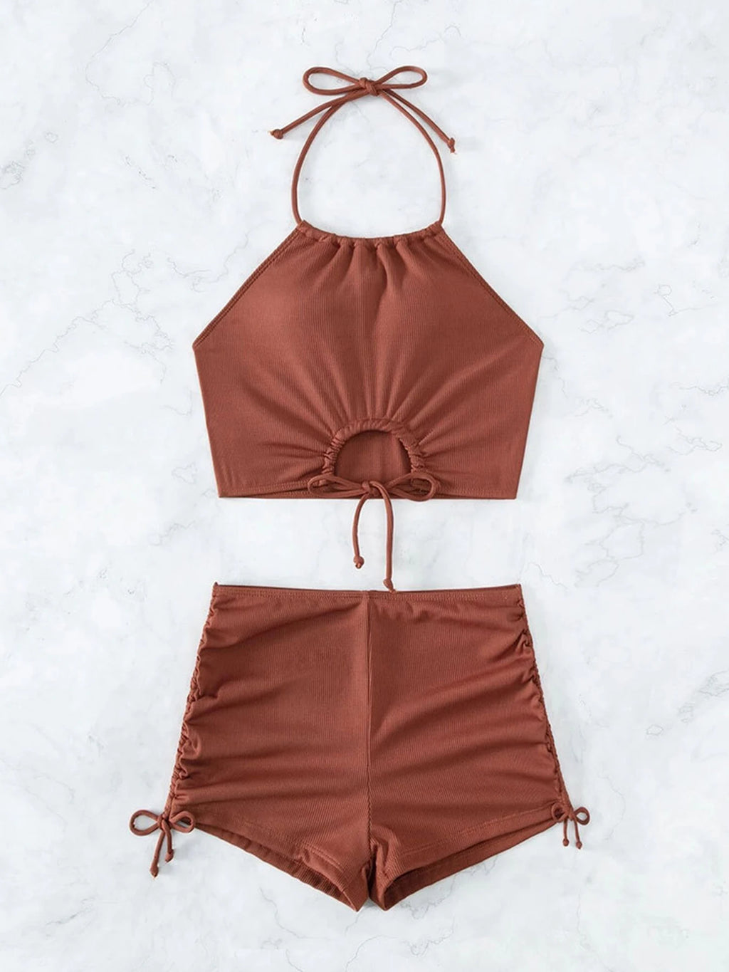 Brown bikini set with halter top and shorts on a light gray background