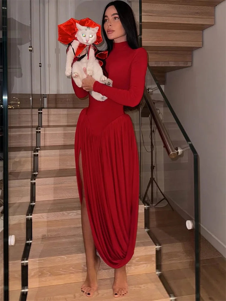 Woman in a red dress holding a white cat with a red bow in a modern interior setting.