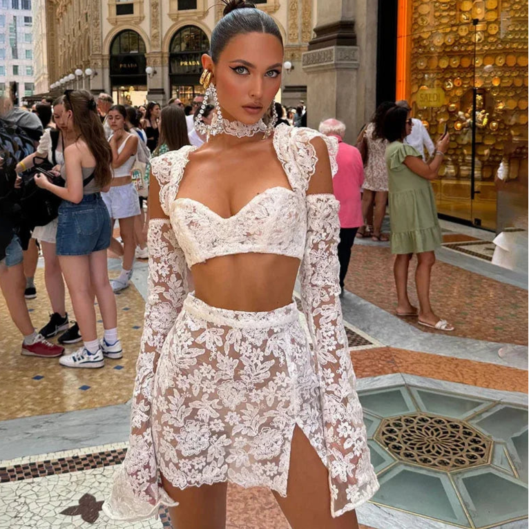 White lace two-piece outfit with off-shoulder crop top and slit mini skirt, worn in a summer outdoor setting