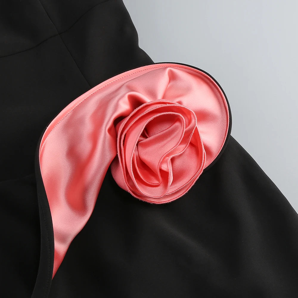 Minimalist black evening dress with striking satin rose at the waist