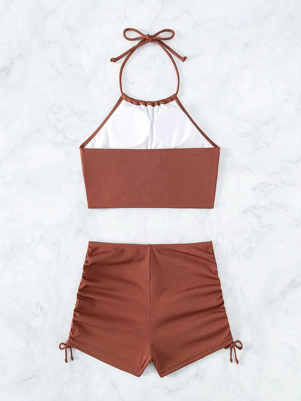 Brown bikini set with halter top and shorts on a white background