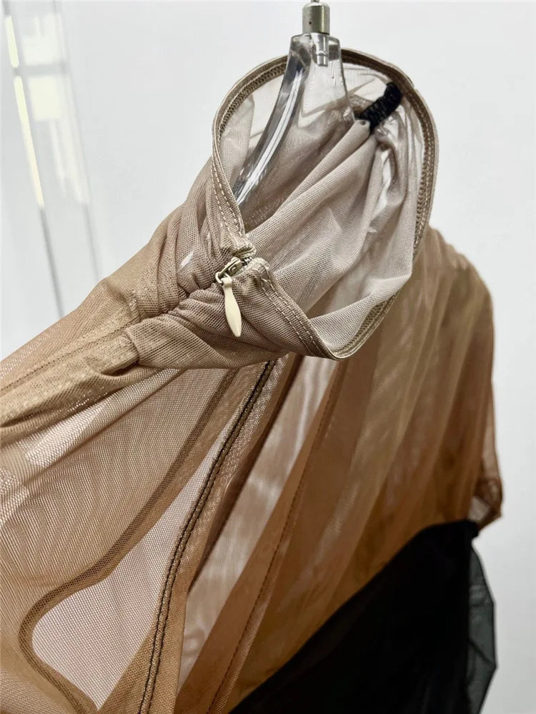 Close-up of a beige jacket with mesh detailing on a mannequin against a white background