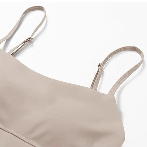 Beige bralette with thin straps on a white background