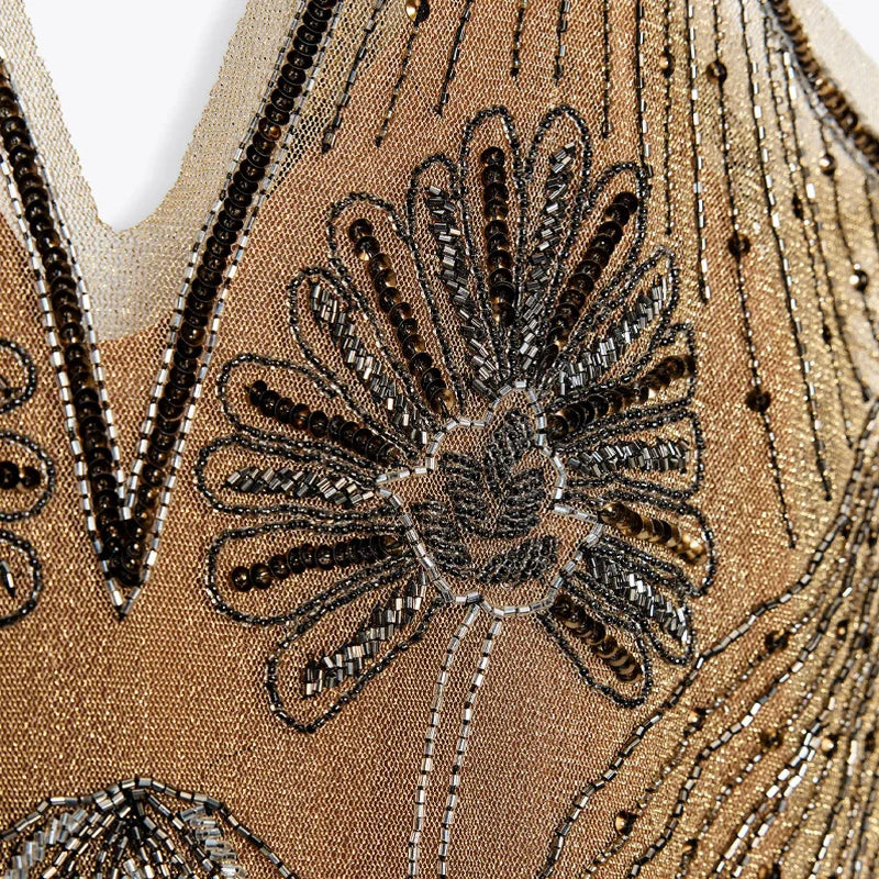 Close-up of a beaded floral design on a beige fabric background