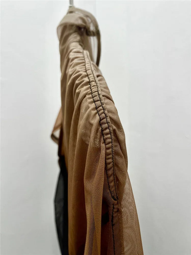 Brown jacket hanging on a white wall
