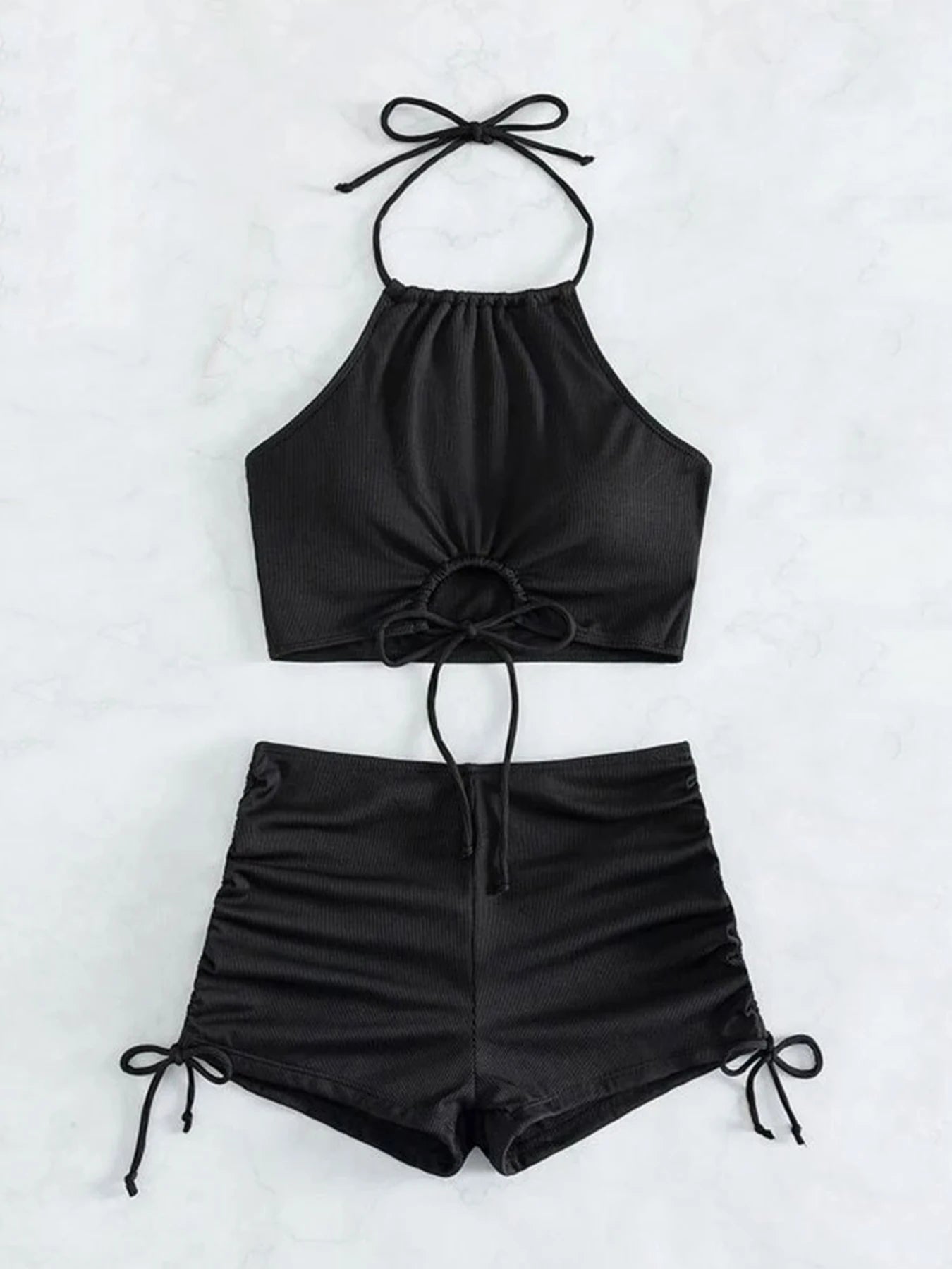 Black halter top and shorts set on a white background