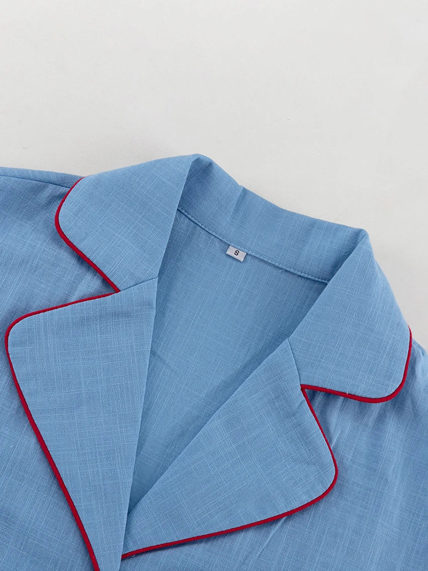 Blue garment with red piping on a light gray background