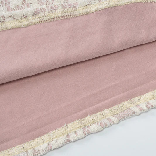 Pink fabric with lace trim on a white background