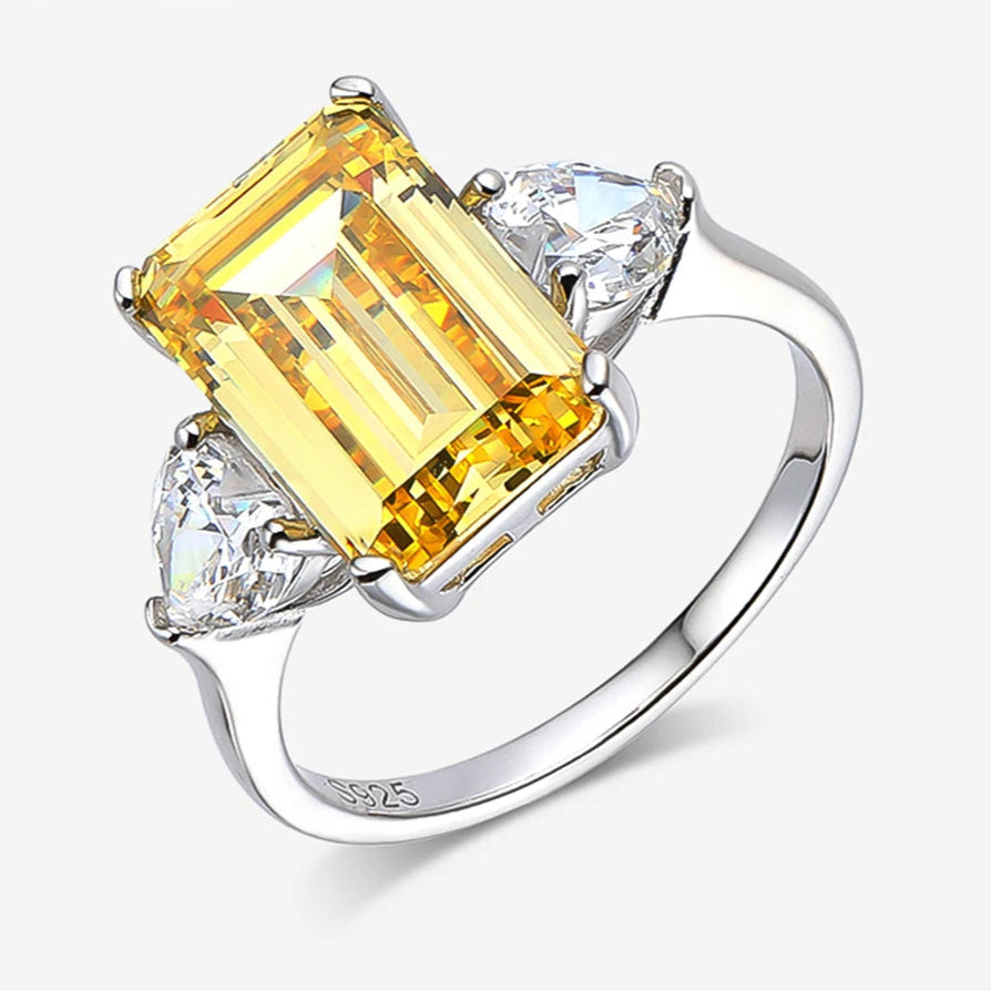 Ring with yellow gemstone and silver band on a white background