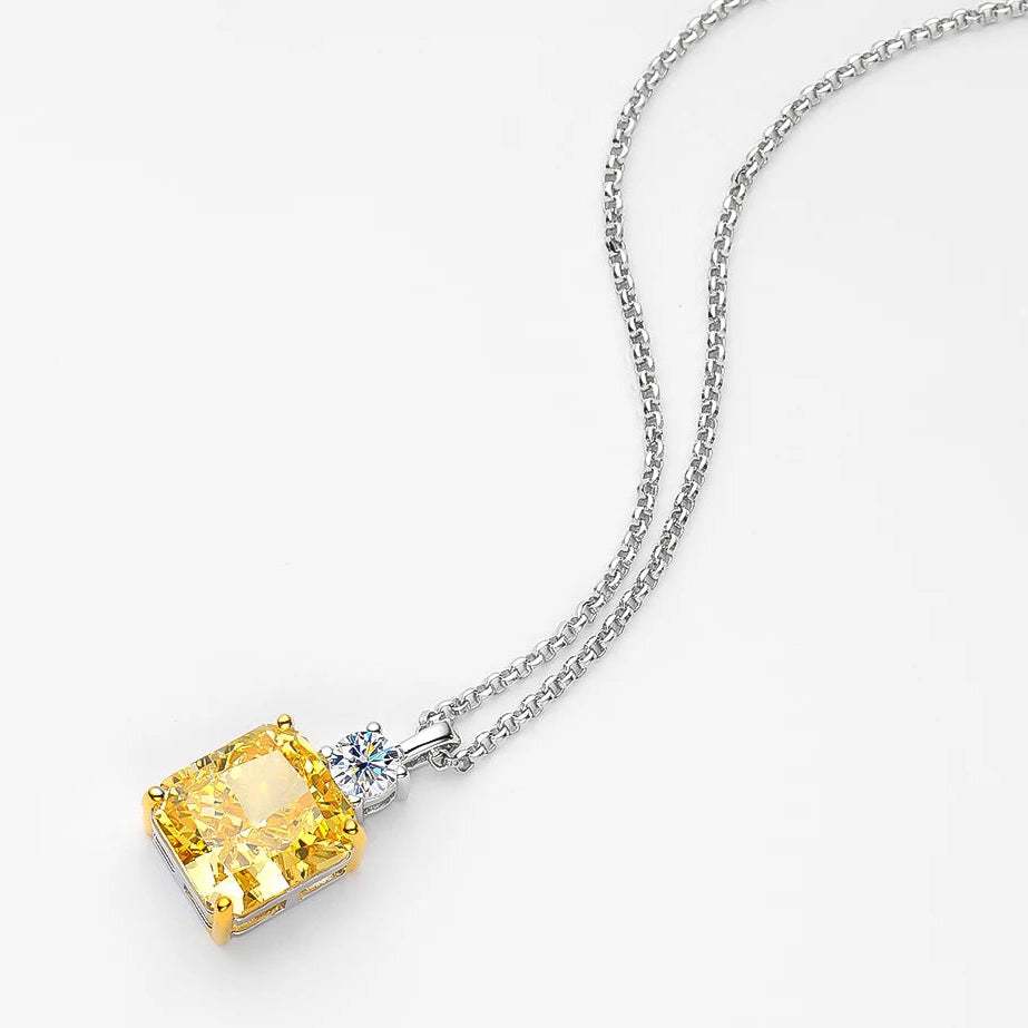 Yellow gemstone pendant on a silver chain against a white background