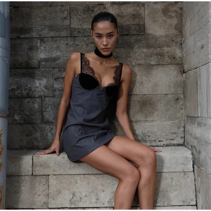 Woman in a dark dress sitting on stone steps against a stone wall.