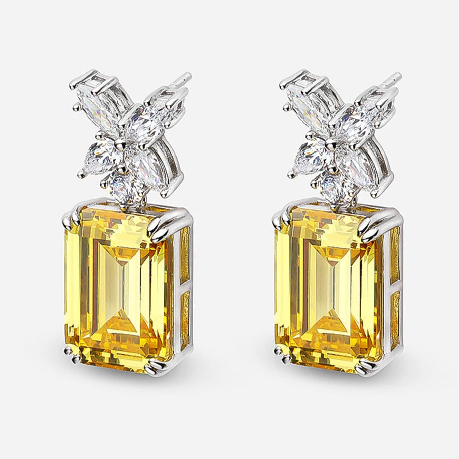 Gold earrings with butterfly design on a white background,